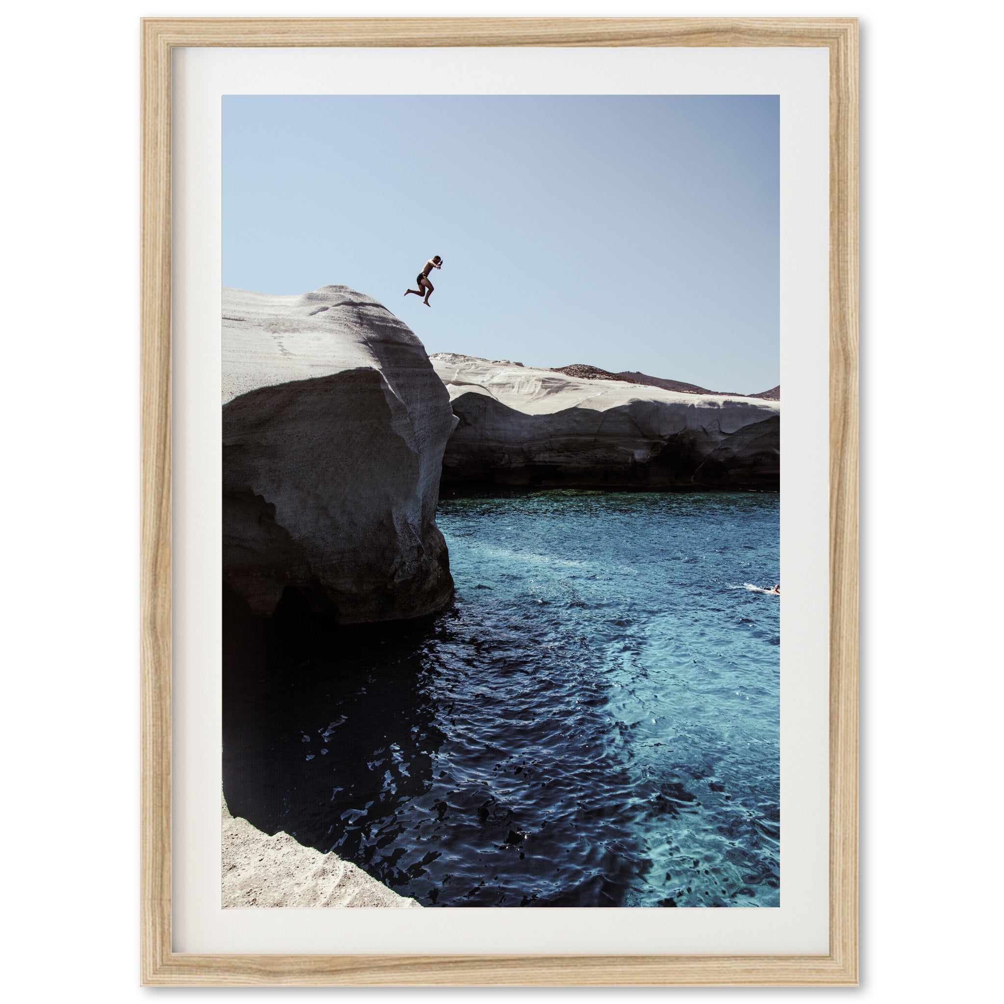 a person jumping off a cliff into a body of water