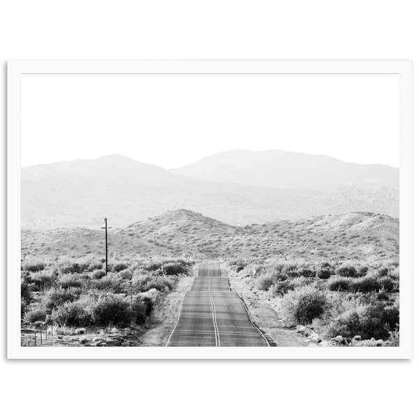 a black and white photo of a road in the desert