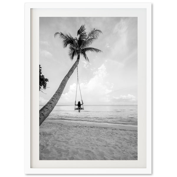 a black and white photo of a person swinging on a palm tree