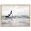 a black and white photo of a woman on a surfboard