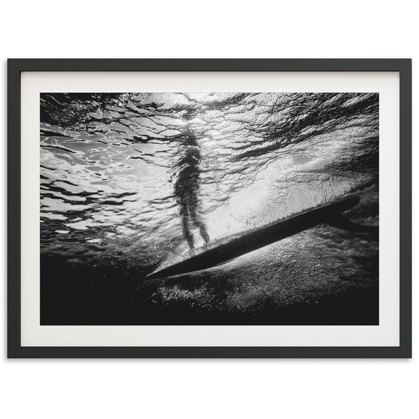 a black and white photo of a person on a surfboard