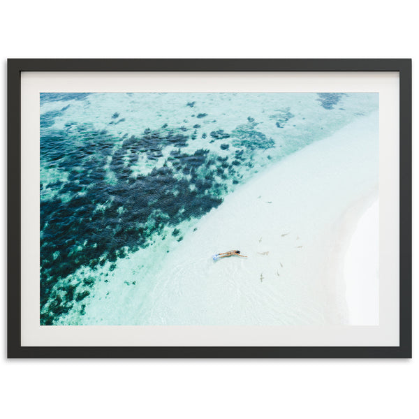 an aerial view of a beach with a boat in the water