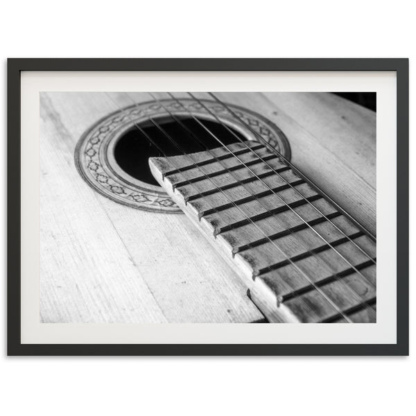 a black and white photo of an acoustic guitar