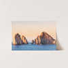 a card with a picture of three rock formations in the ocean