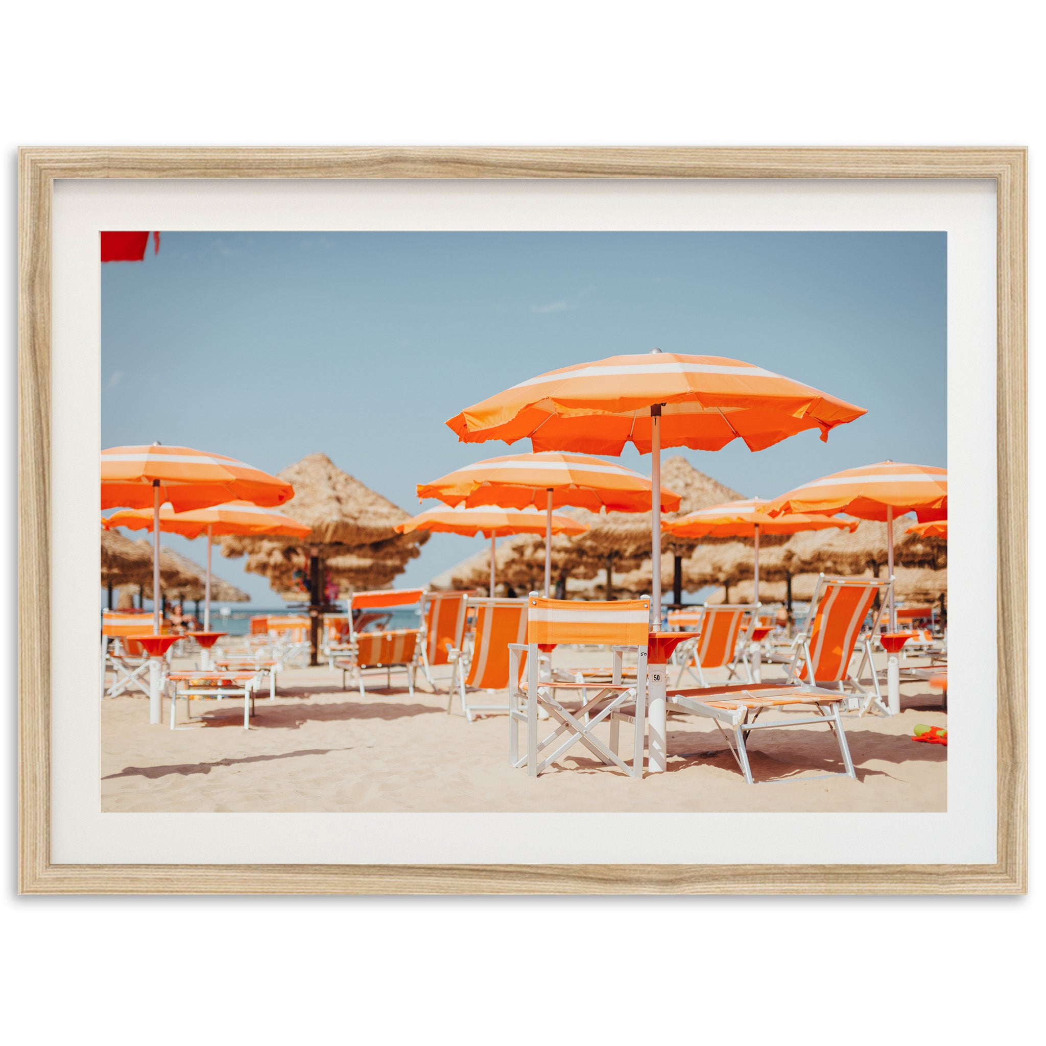 a group of orange umbrellas sitting on top of a sandy beach