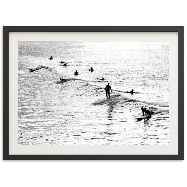 a black and white photo of surfers in the ocean