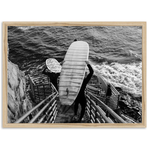 a black and white photo of a person holding a surfboard