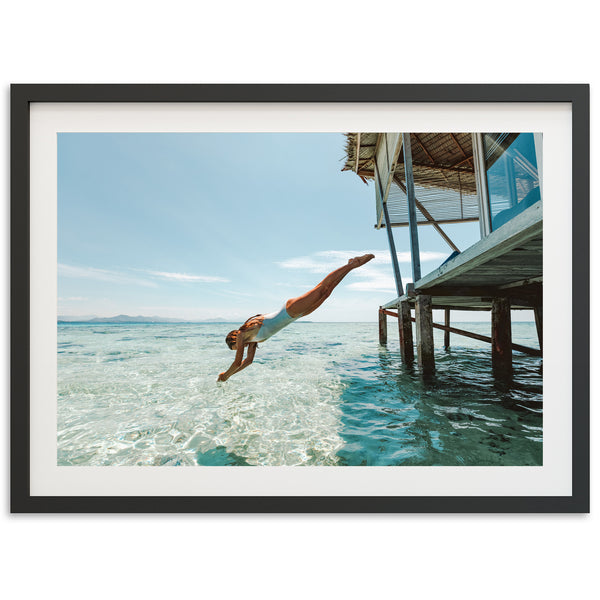 a man diving into the ocean from a dock