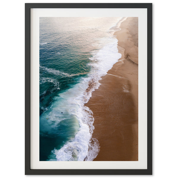 an aerial view of a beach with waves coming in