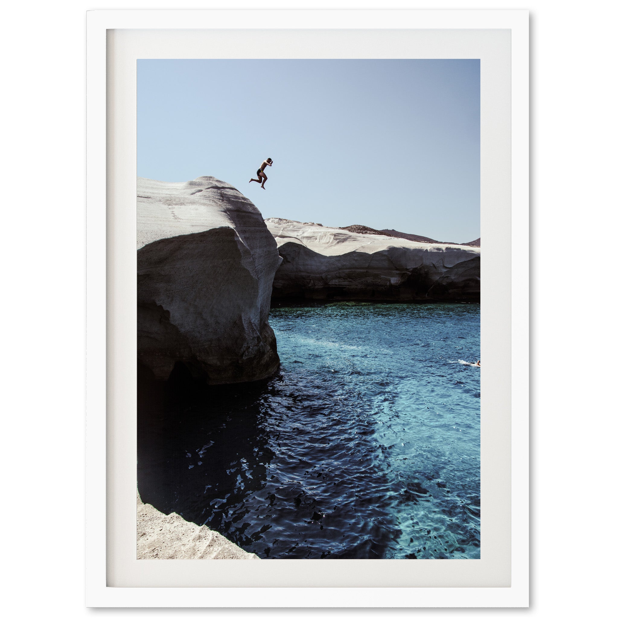 a person jumping off a cliff into a body of water