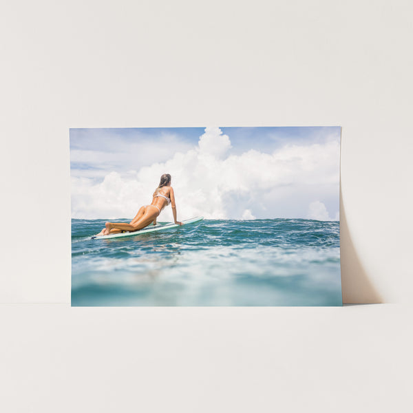 a woman is sitting on a surfboard in the ocean