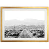 a black and white photo of a desert road