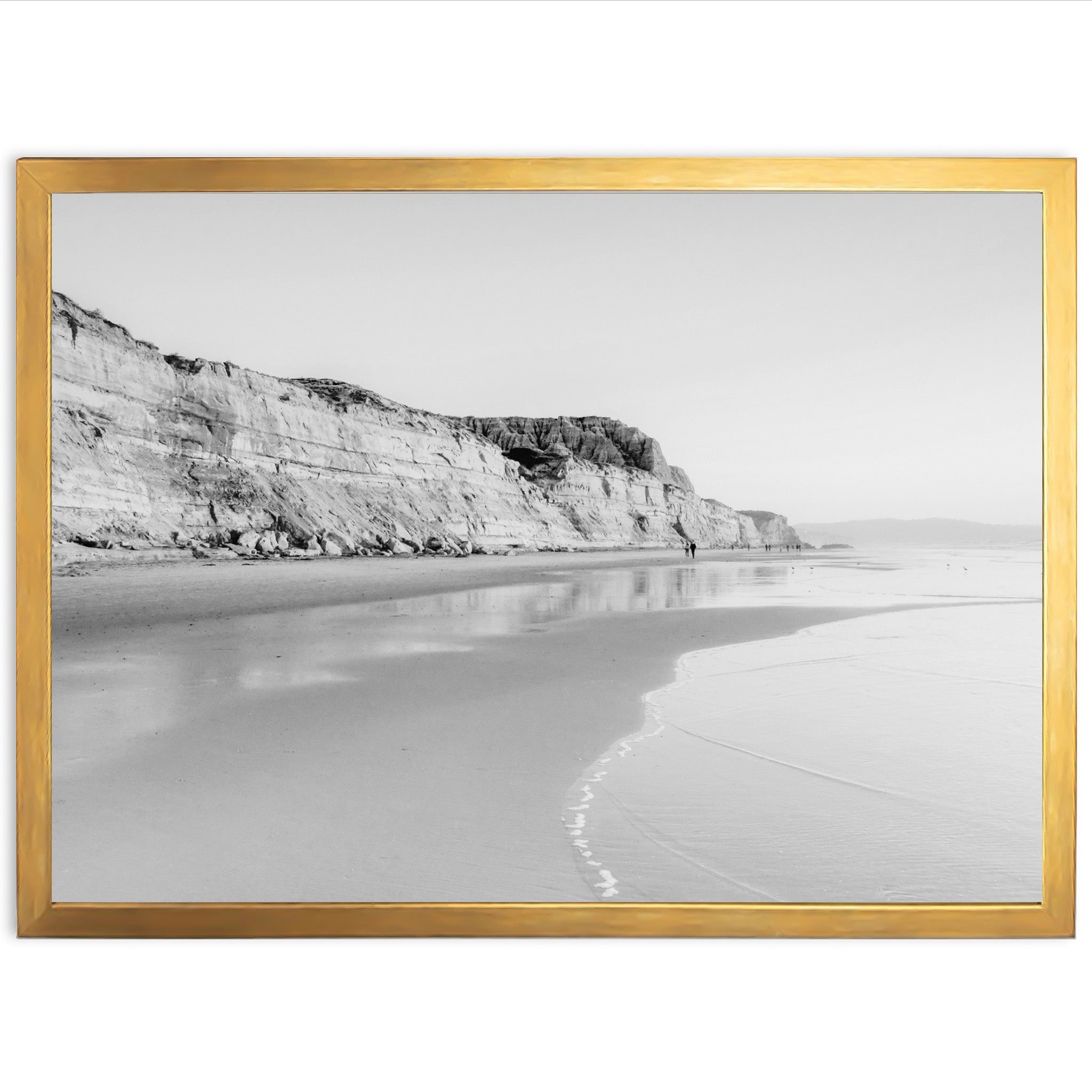 a black and white photo of a beach and cliffs