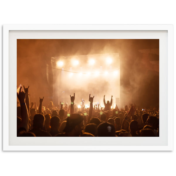 a crowd of people at a concert with their hands in the air