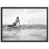 a black and white photo of a woman on a surfboard