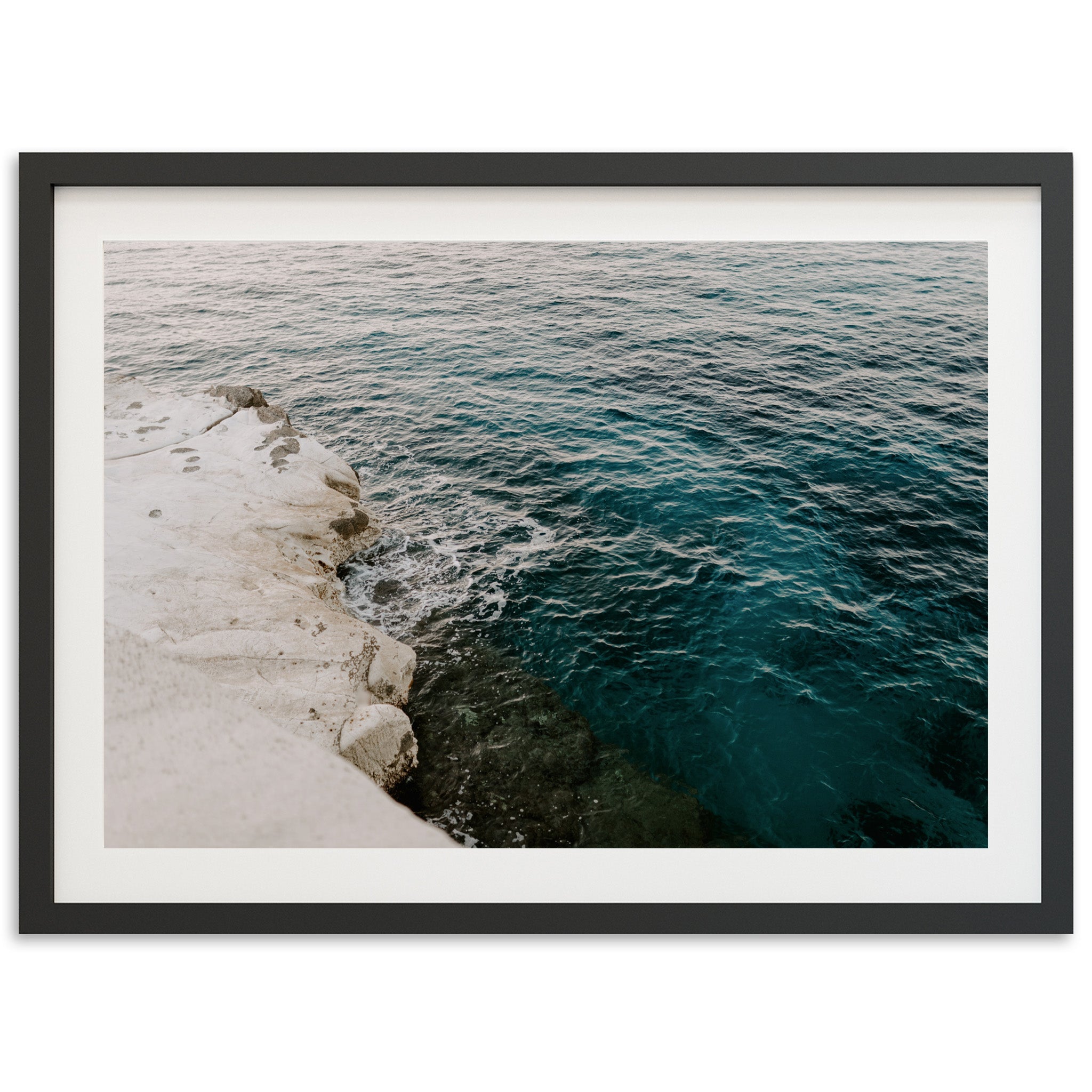 a picture of the ocean and a rock wall