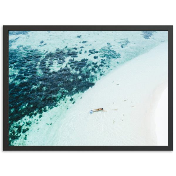 an aerial view of a beach with a boat in the water