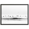 a black and white photo of surfers in the ocean