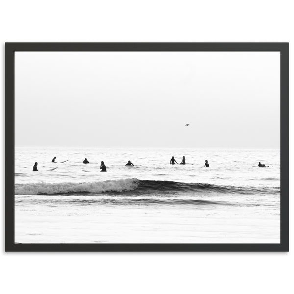 a black and white photo of surfers in the ocean