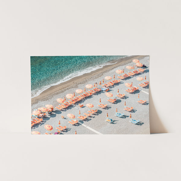 an aerial view of a beach with umbrellas and chairs