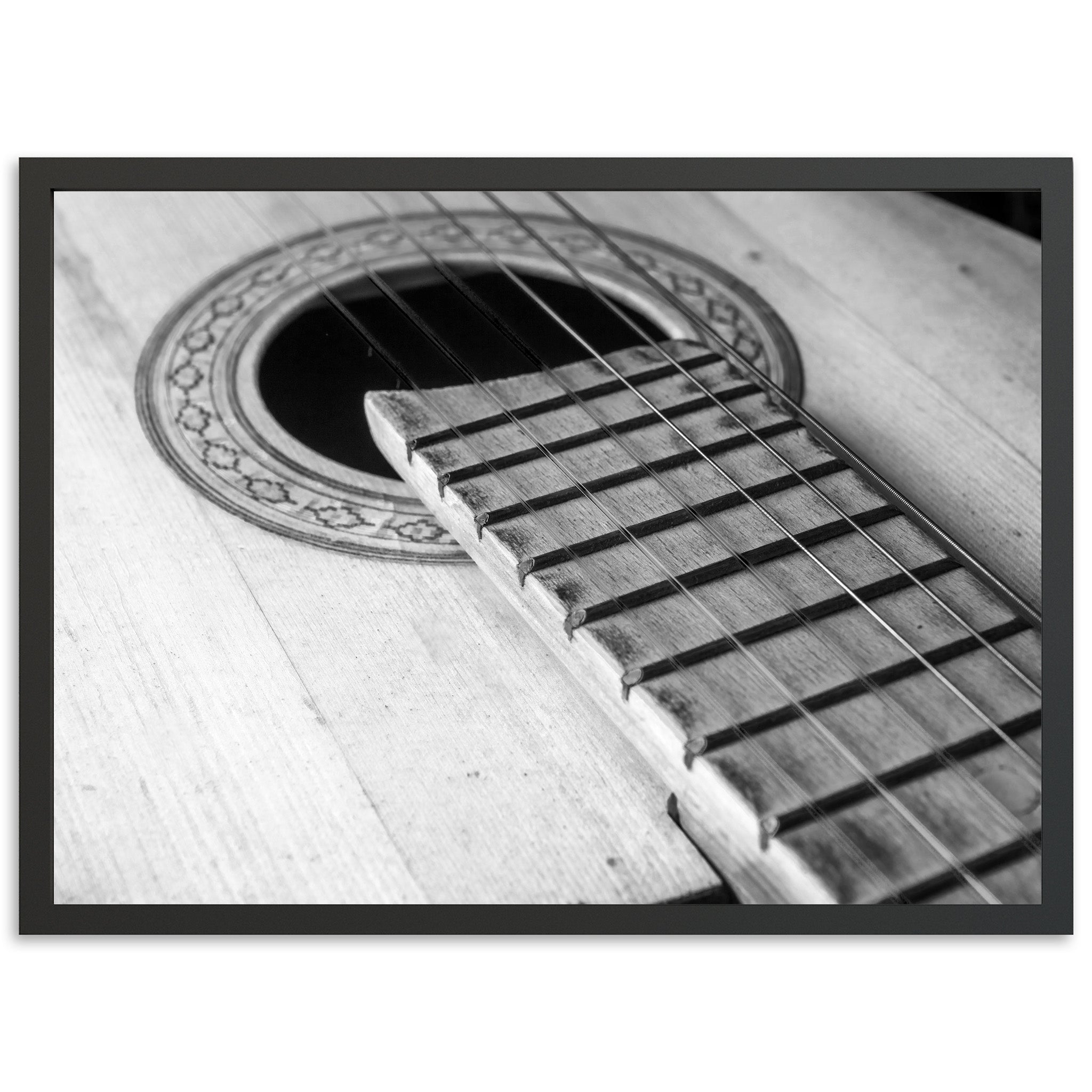 a black and white photo of an acoustic guitar