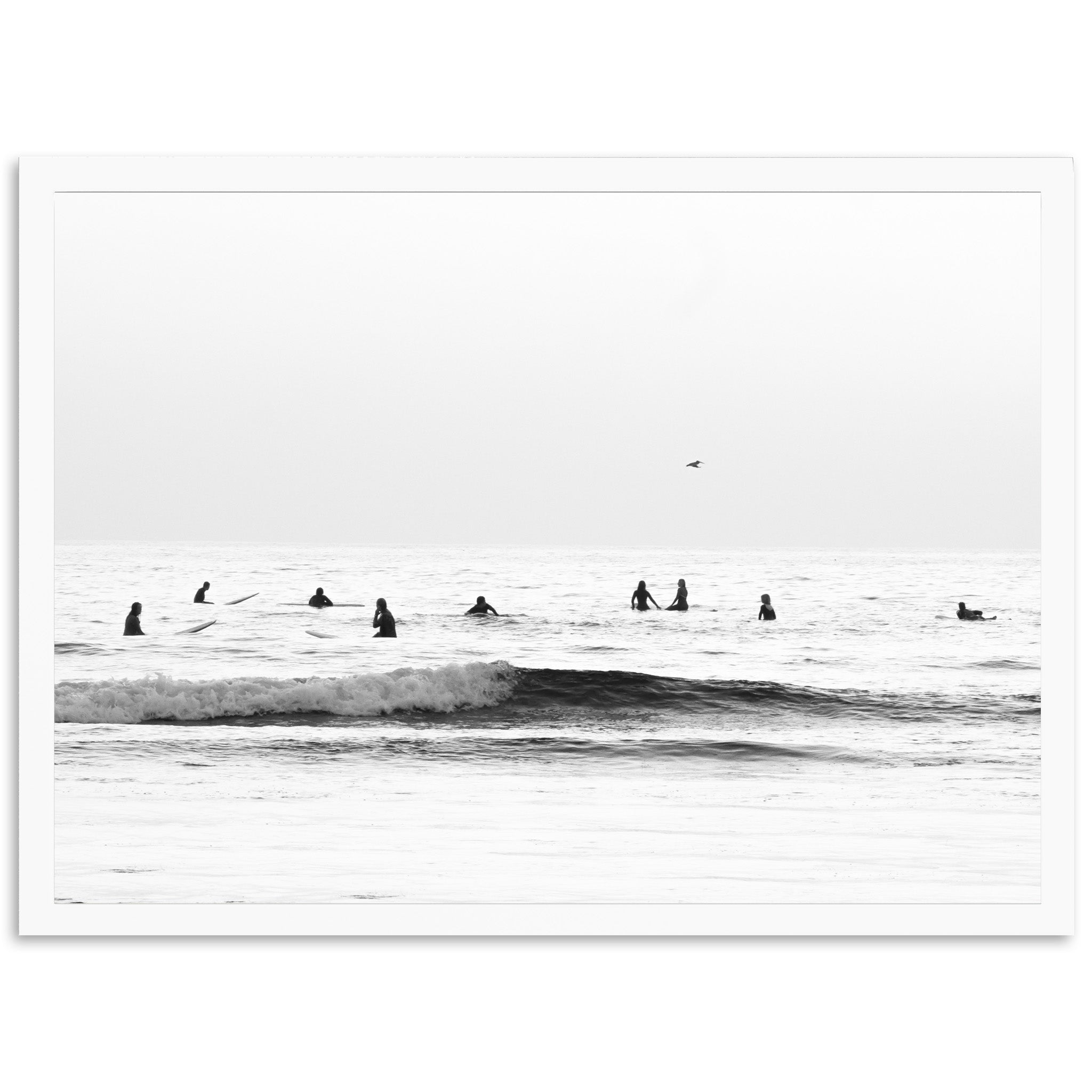 a black and white photo of surfers in the ocean