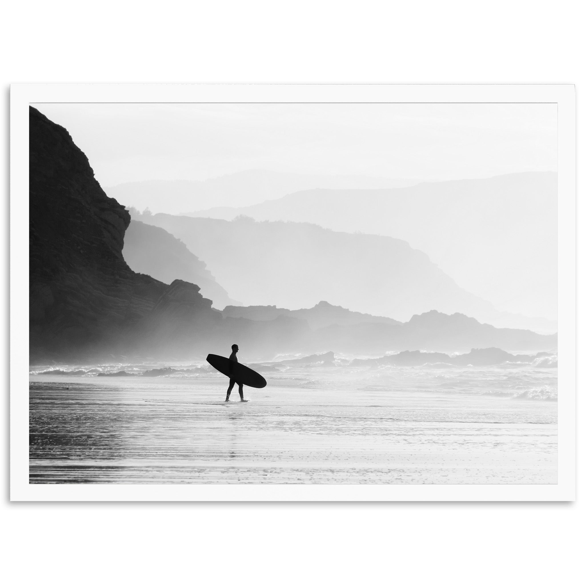 a black and white photo of a person carrying a surfboard