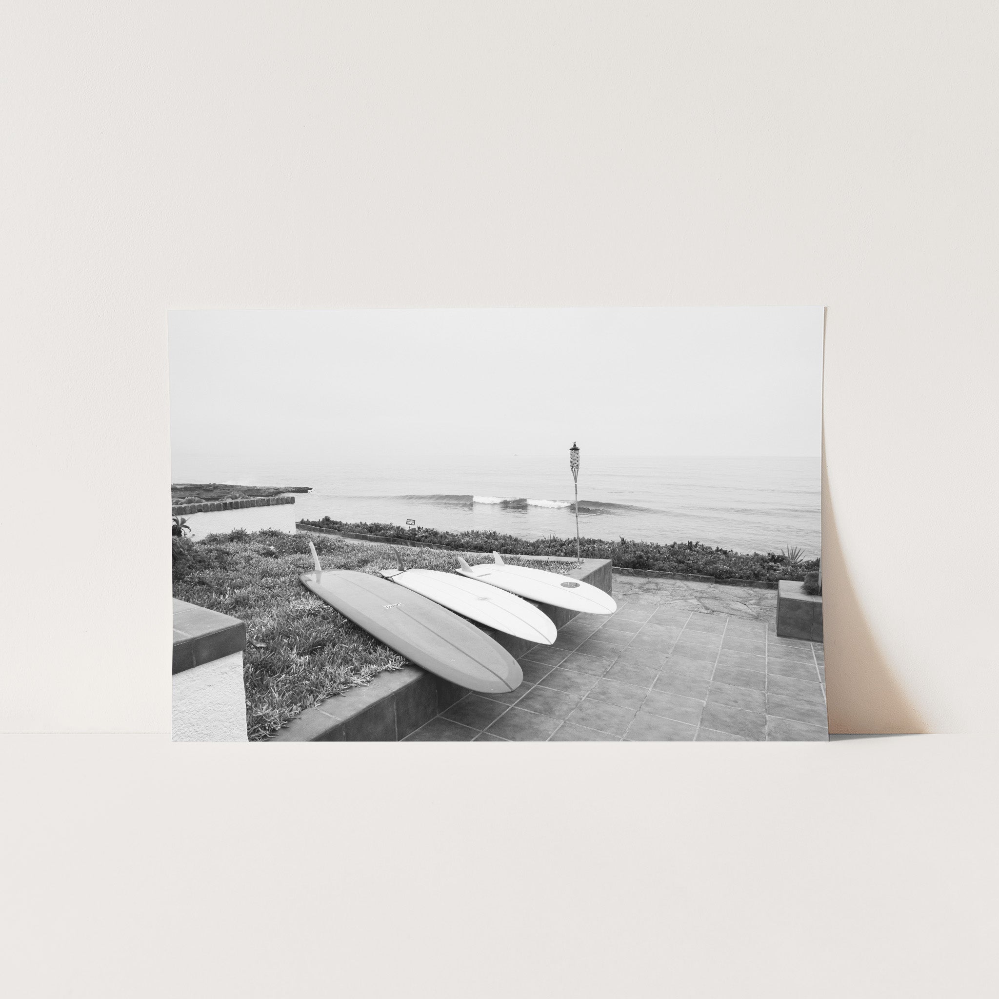 a black and white photo of a surfboard on the beach