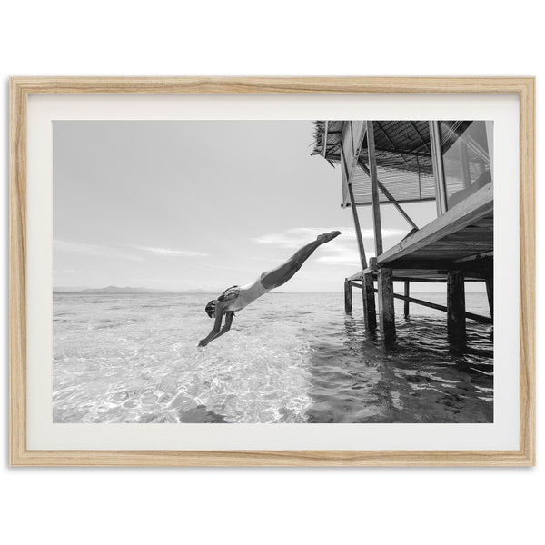 a black and white photo of a person diving into the water