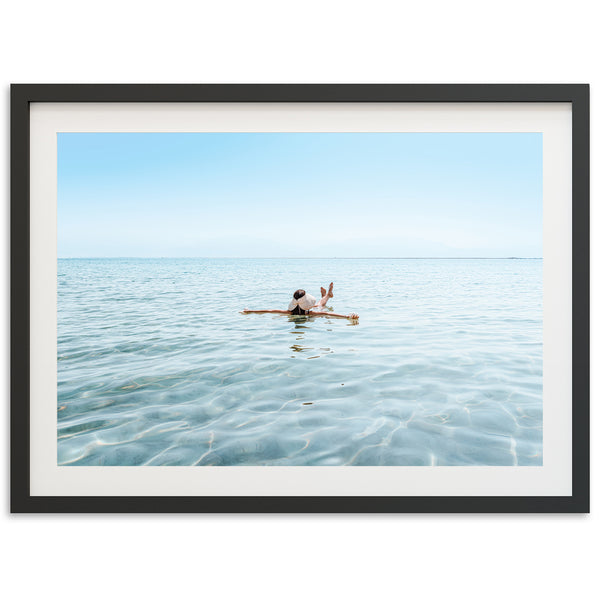 a person sitting on a surfboard in the middle of the ocean