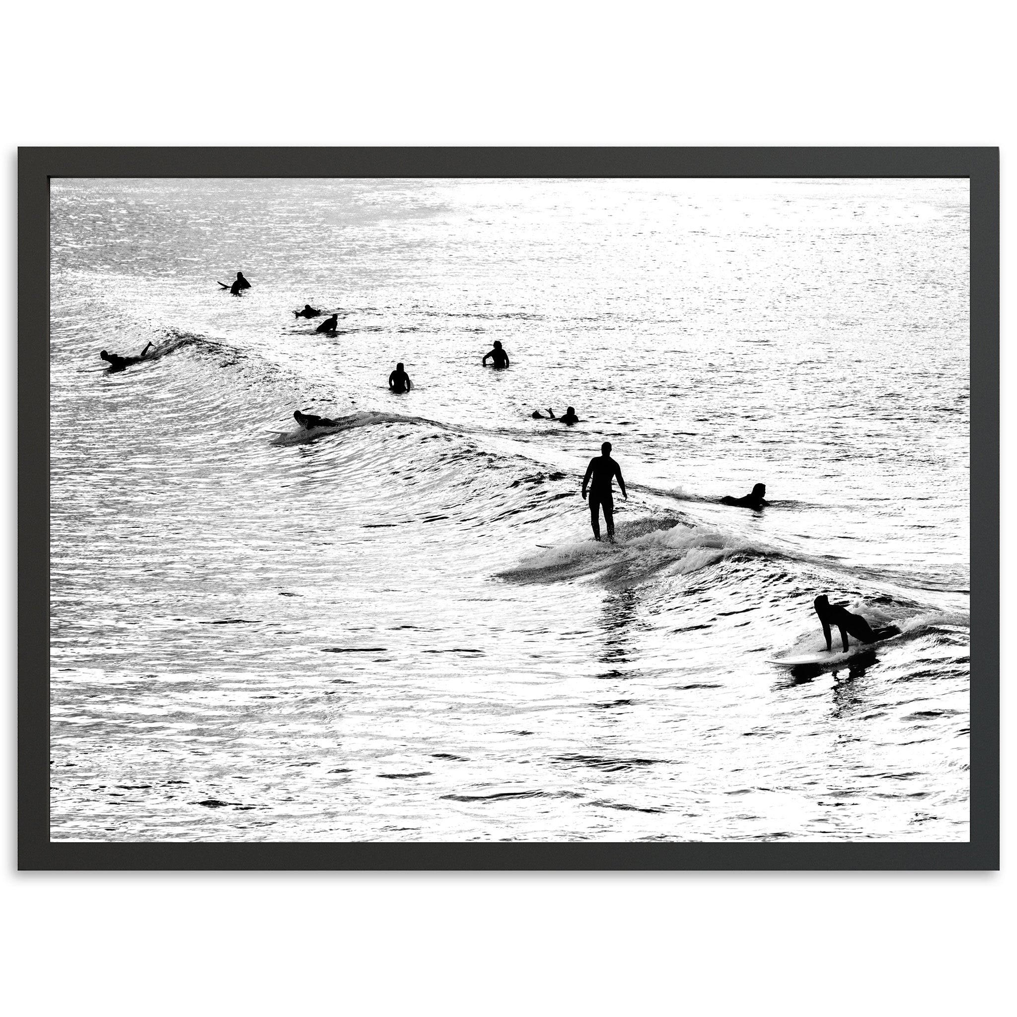 a black and white photo of people surfing in the ocean