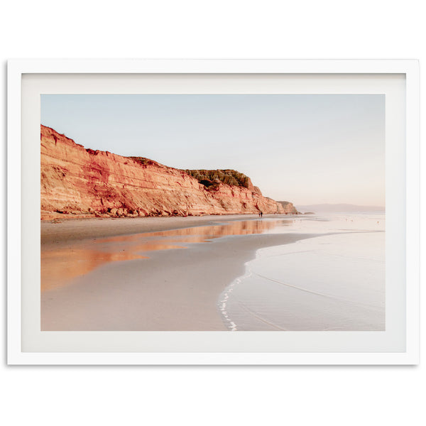 a picture of a beach with a cliff in the background