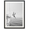 a black and white photo of a person jumping off a boat