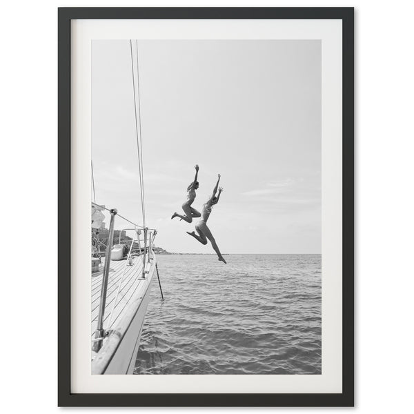 a black and white photo of a person jumping off a boat