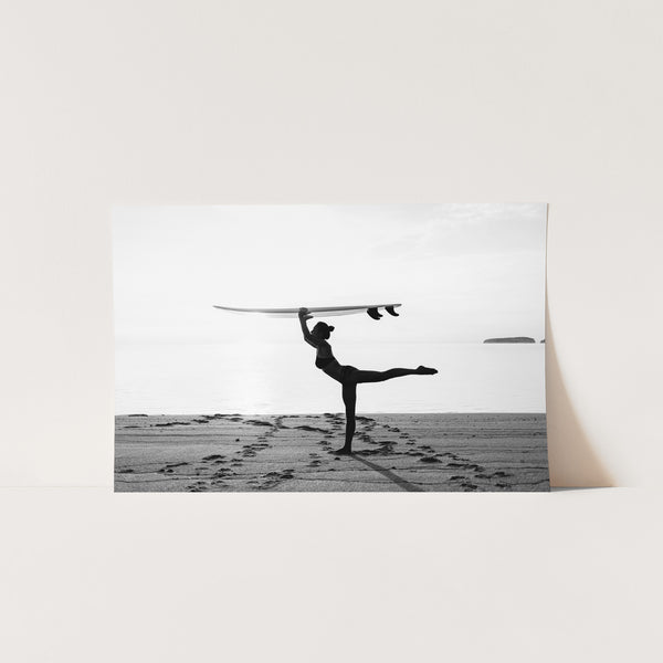 a black and white photo of a person doing a handstand on the beach