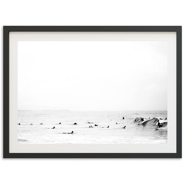 a black and white photo of surfers in the ocean