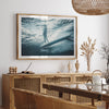 a picture of a person on a surfboard hangs above a dining room table