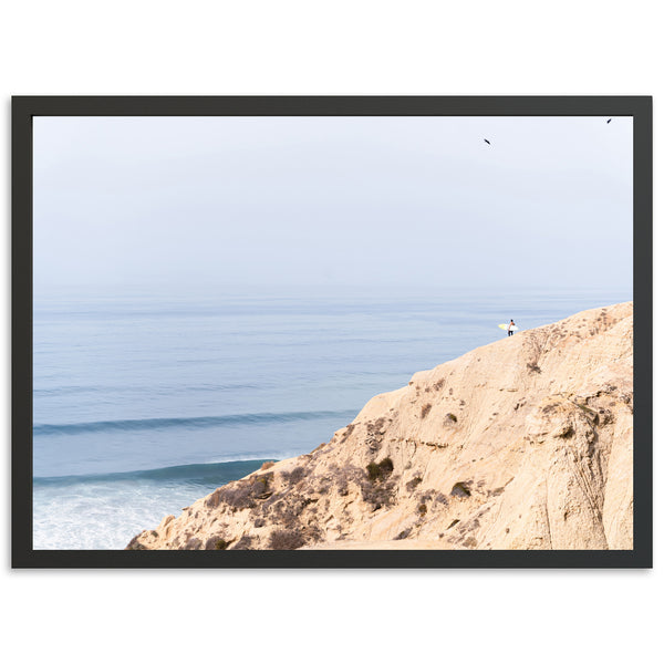 a person standing on top of a cliff near the ocean