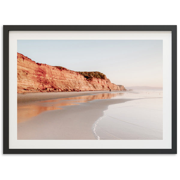 a picture of a beach with a cliff in the background