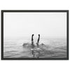 a black and white photo of a person swimming in the ocean