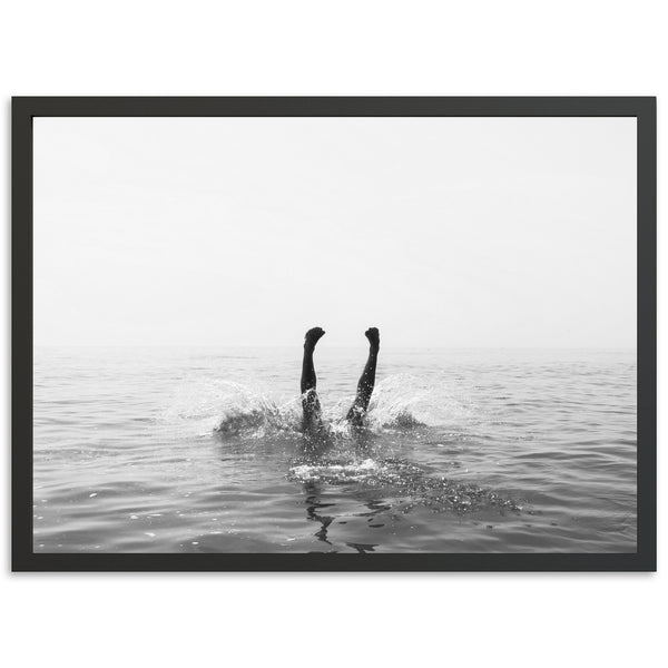 a black and white photo of a person swimming in the ocean