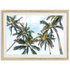 a framed photograph of palm trees against a blue sky