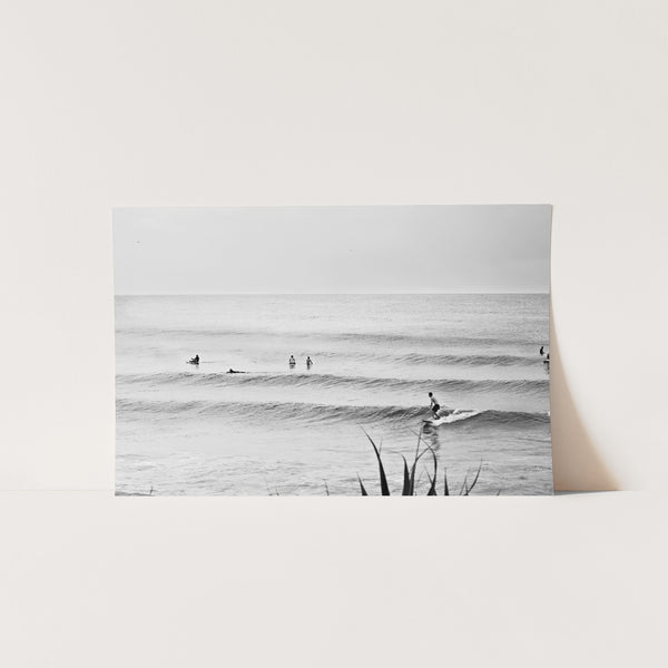 a black and white photo of surfers in the ocean