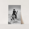 a black and white photo of a cowboy on a horse