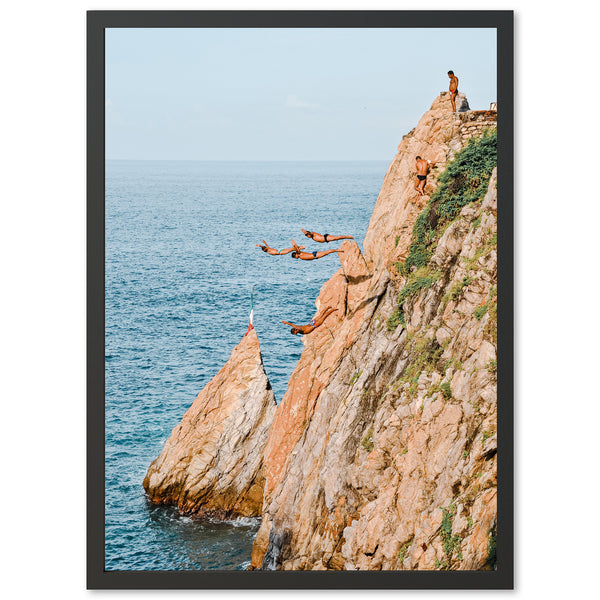 a group of people jumping off of a cliff into the ocean