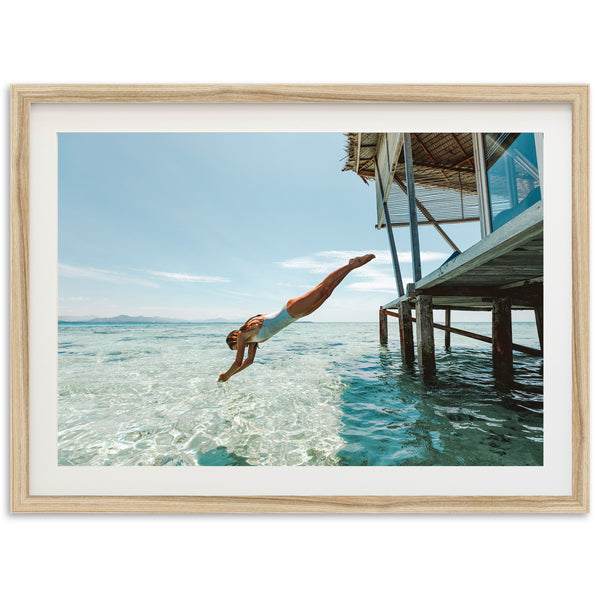 a man diving into the ocean from a dock