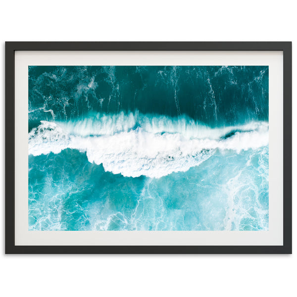 an aerial view of a wave crashing on the beach