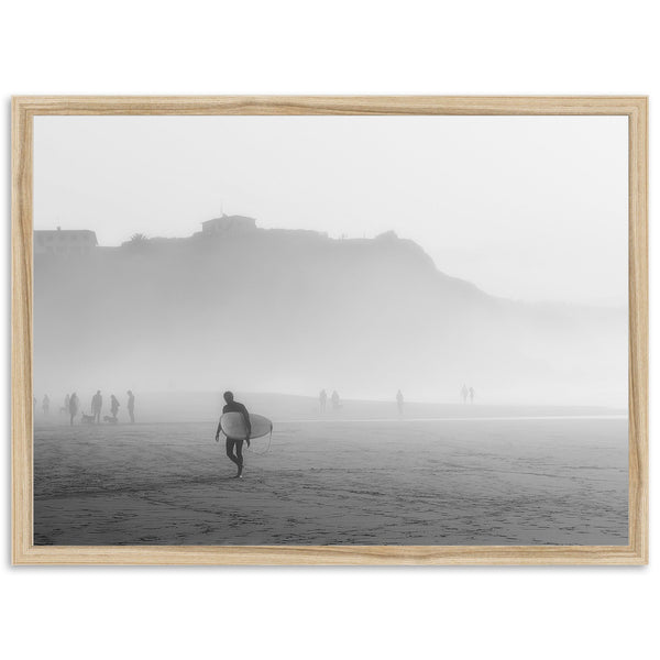 a black and white photo of a man carrying a surfboard