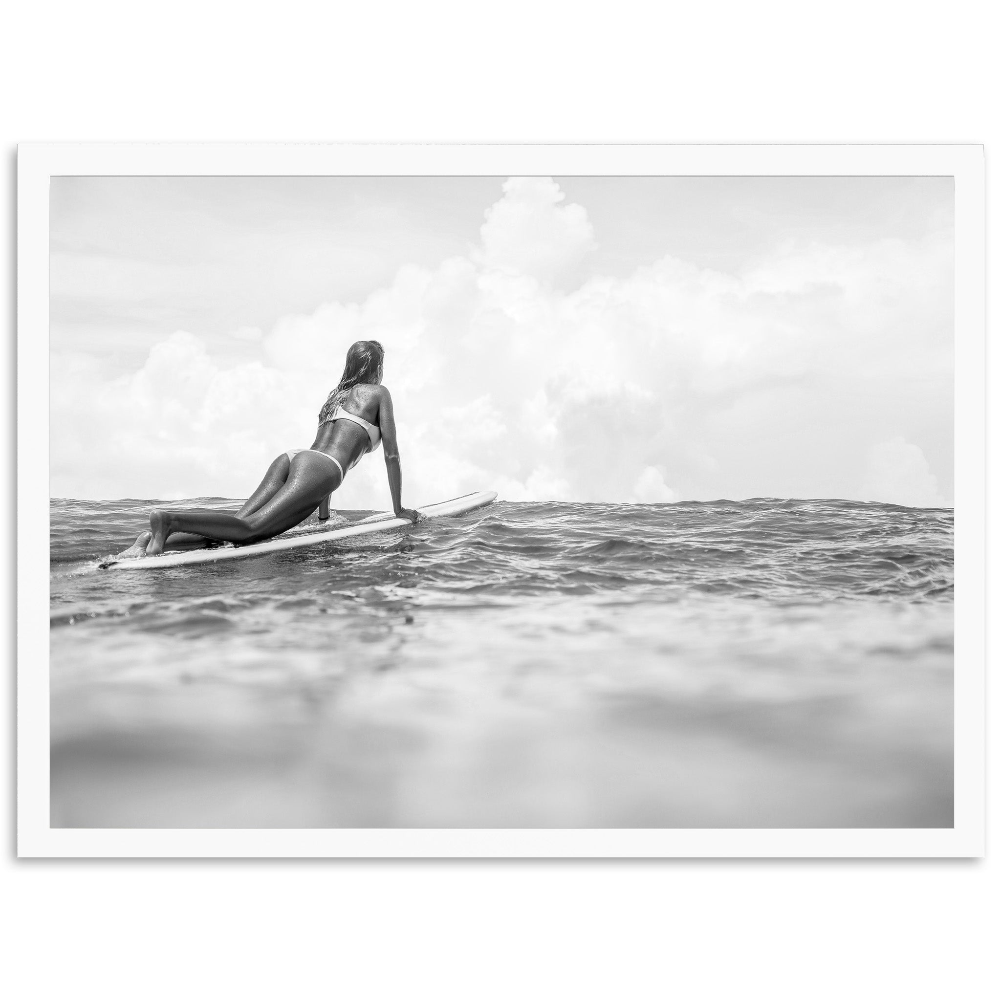 a black and white photo of a woman on a surfboard