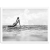 a black and white photo of a woman on a surfboard